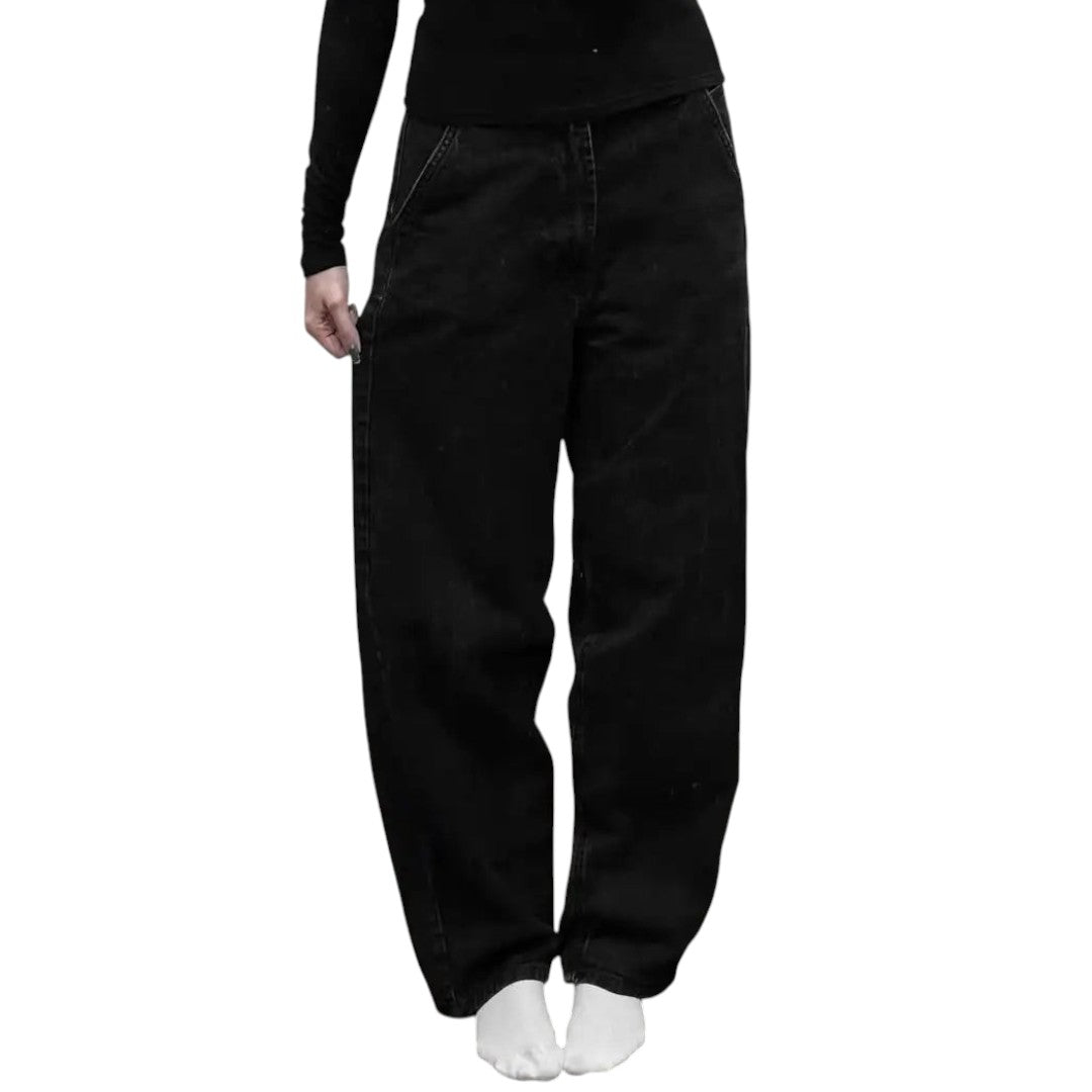 AuraXclusive Y2K style black baggy denim jeans featuring white cross and ornate scroll embroidery on the back pockets