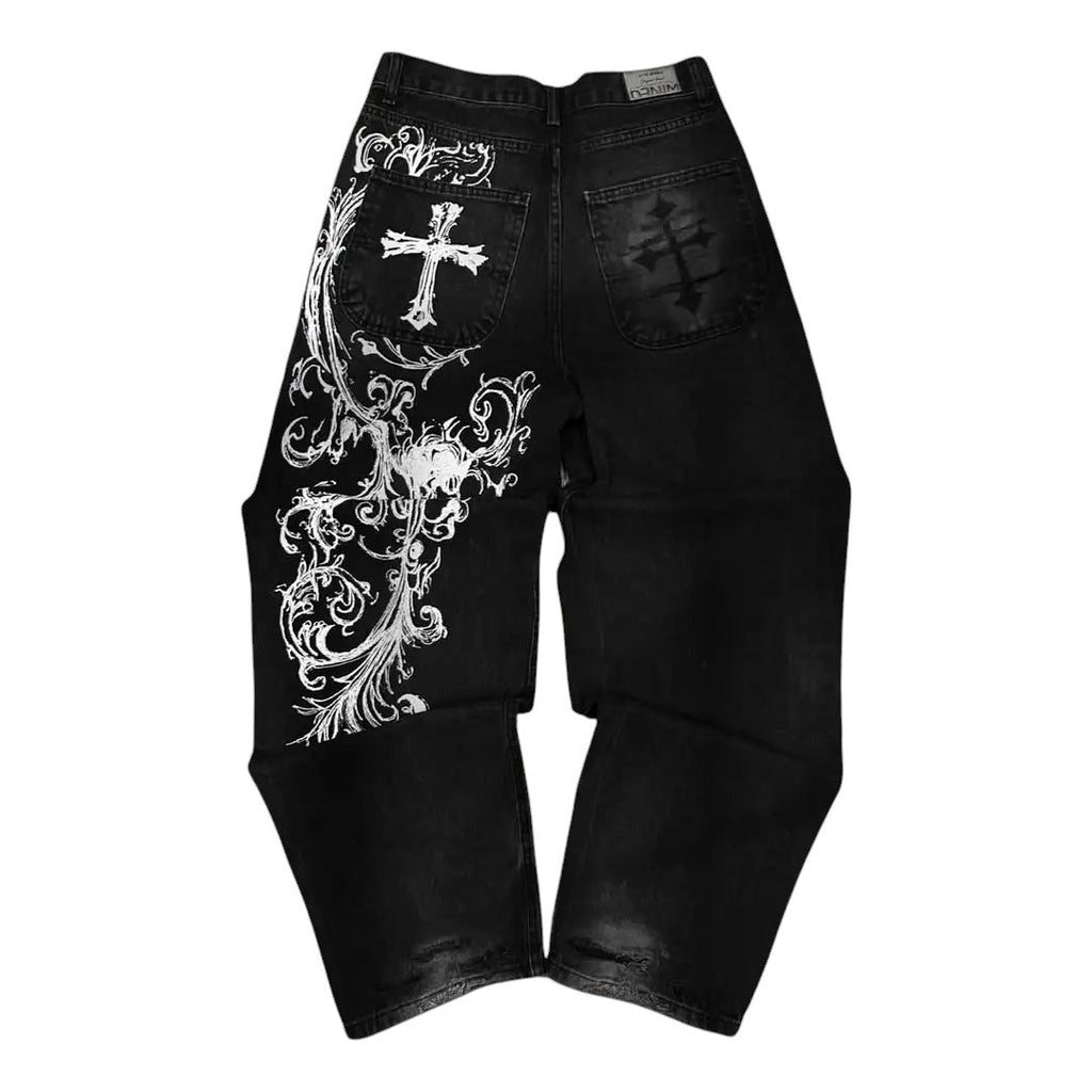 AuraXclusive baggy black denim jeans with intricate white cross and floral embroidery in a Y2K hip hop style.
