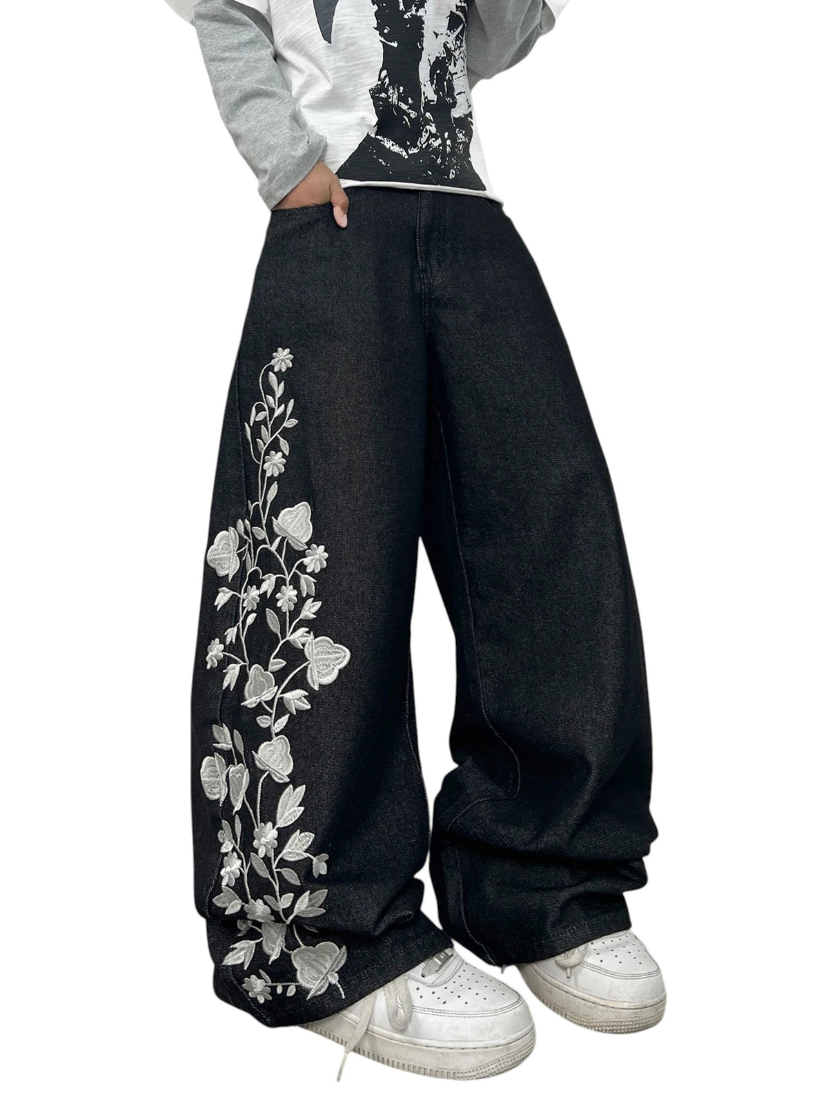 AuraXclusive men's loose black denim jeans featuring intricate white floral embroidery on the leg in a Y2K style.