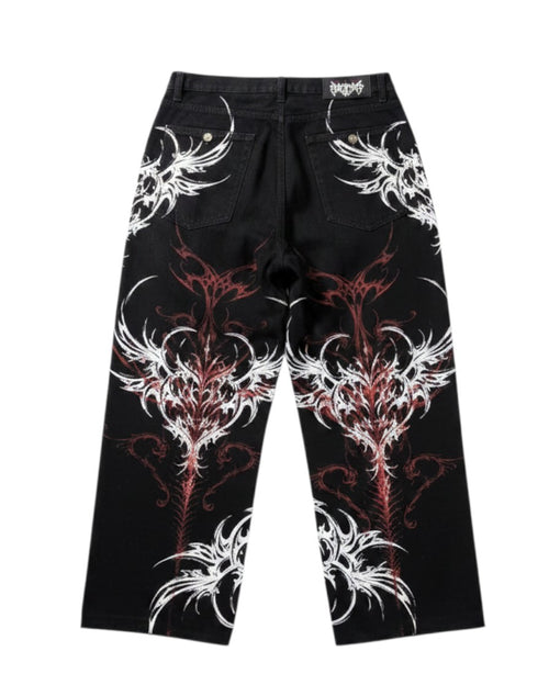 AuraXclusive black baggy jeans featuring a bold red and white tribal flame print in a Y2K gothic streetwear style.