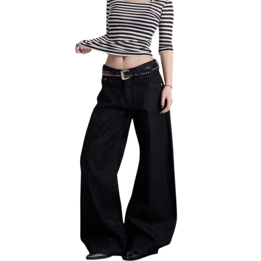 AuraXclusive women wearing high-waisted black wide-leg jeans with a studded belt and a striped long-sleeve top.