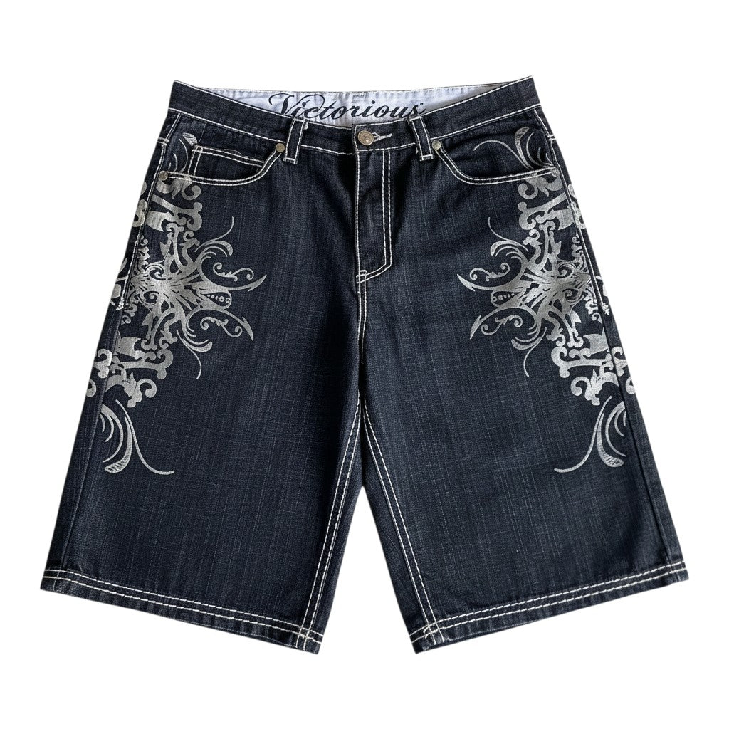 AuraXclusive dark denim shorts with intricate silver embroidery and white contrast stitching in a loose hip hop style.