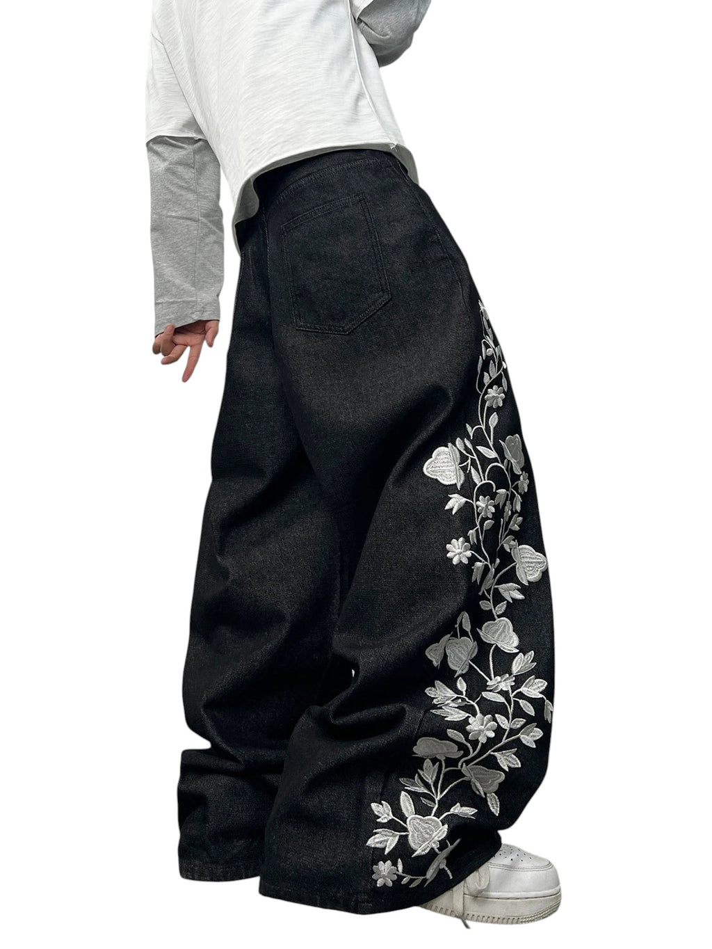 AuraXclusive men's loose black denim jeans featuring intricate white floral embroidery in a Y2K streetwear style.