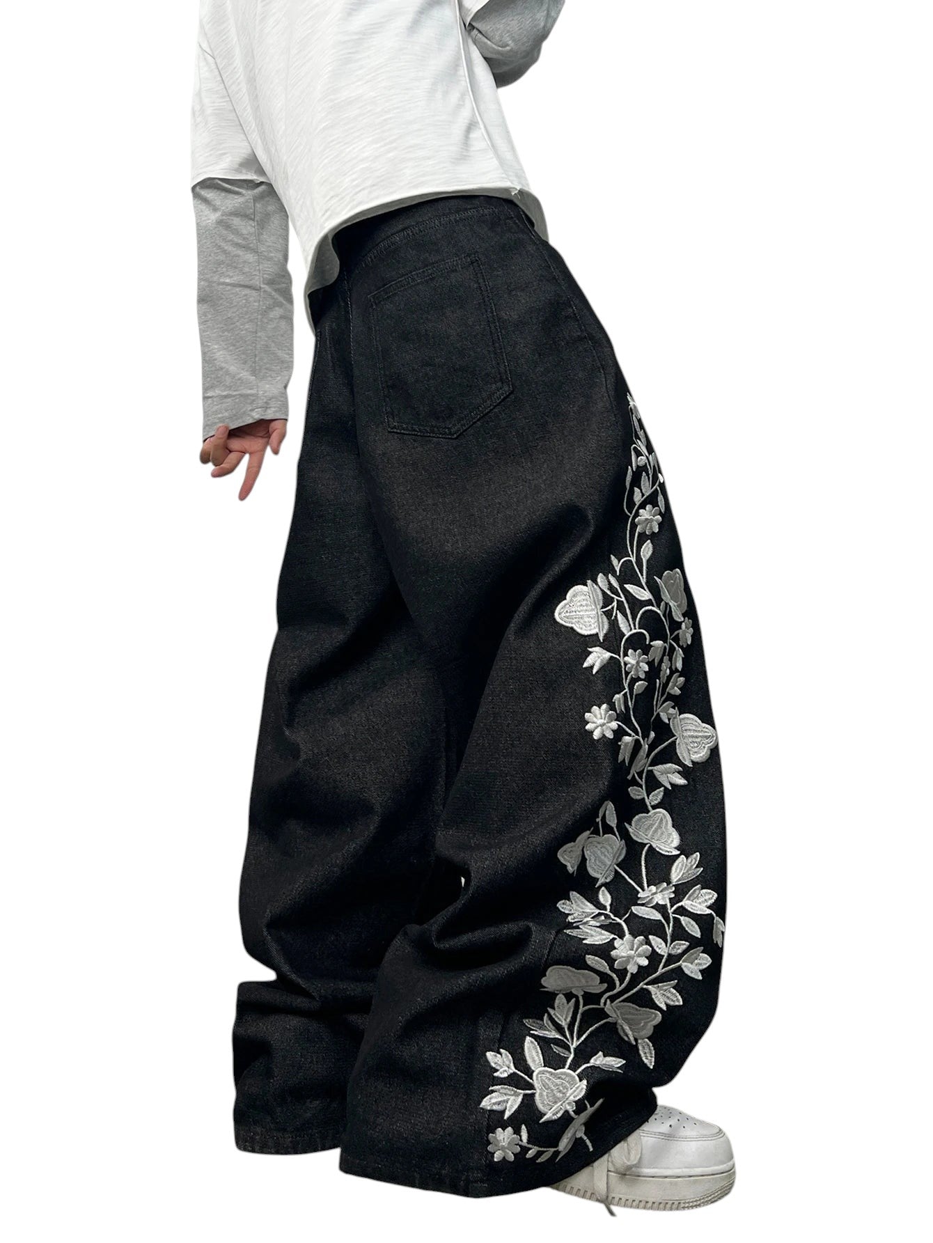AuraXclusive men's loose black denim jeans featuring intricate white floral embroidery in a Y2K streetwear style.