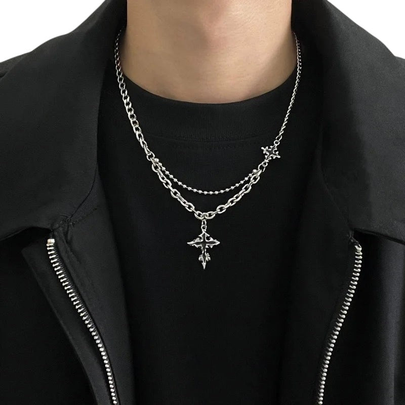 AuraXclusive vintage gothic cross pendant necklace with a layered stainless steel chain on a person in black clothing.