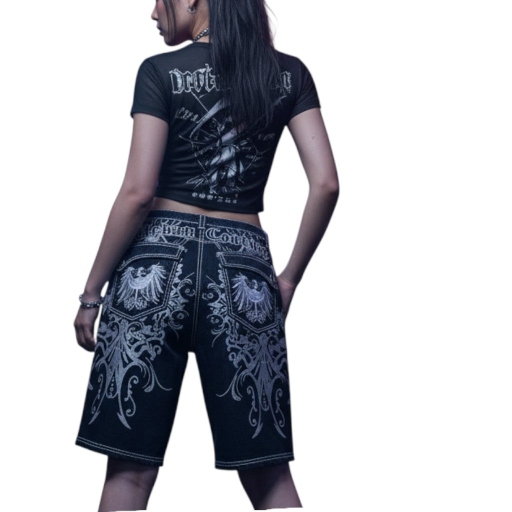AuraXclusive Rapture denim jorts featuring intricate white embroidery and prints on black cotton, knee-length fit.